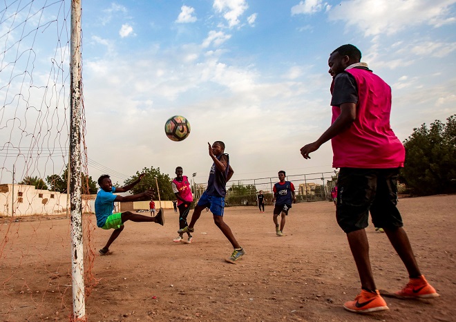 شبان سودانيون يلعبون كرة القدم في ملعب ترابي في العاصمة الخرطوم